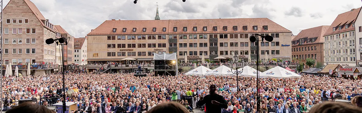Eine große Menschenmenge singt auf einem Marktplatz