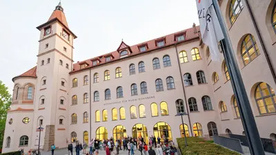 ein großes Gebäude mit vielen Stockwerken und Fenstern sowie einem Turm
