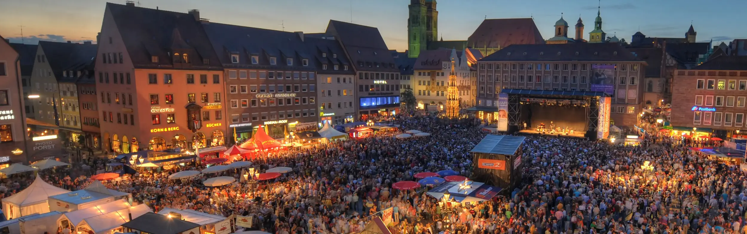 Foto des Nürnberger Hauptmarkts bei Nacht mit tausenden Besuchern