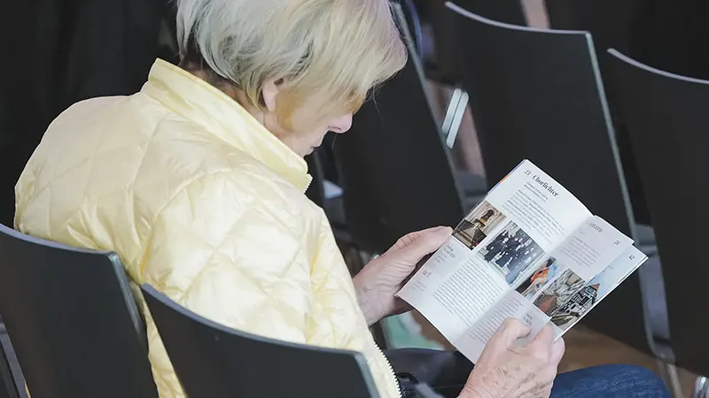 Foto einer Person, die in einem Programmbuch liest.